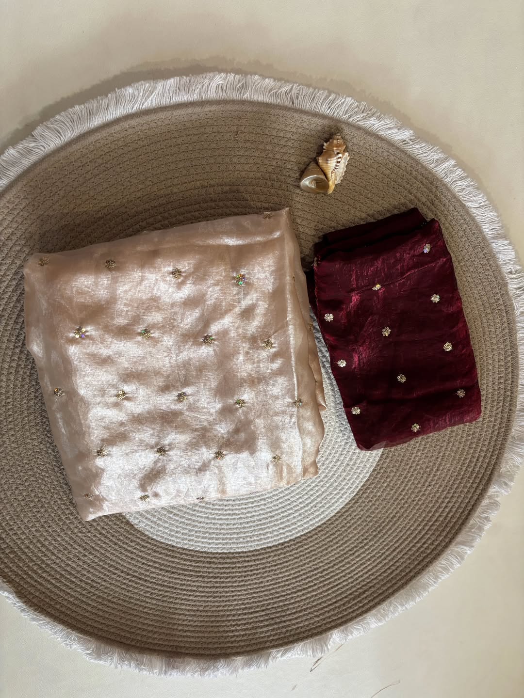 A Soft Beige Color Stardust Satin Saree Dual Shaded Sequins Jari Butti Work Allover the saree paired with Deep Maroon Color Sequins work Blouse