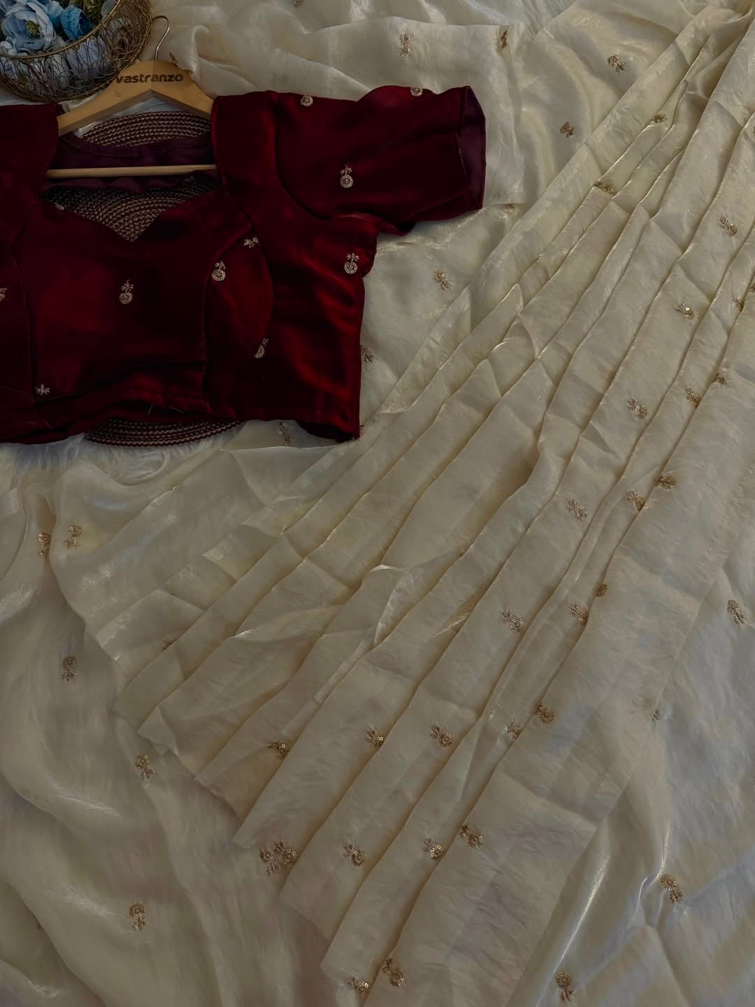 A Soft Beige Color Stardust Satin Saree Dual Shaded Sequins Jari Butti Work Allover the saree paired with Deep Maroon Color Sequins work Blouse