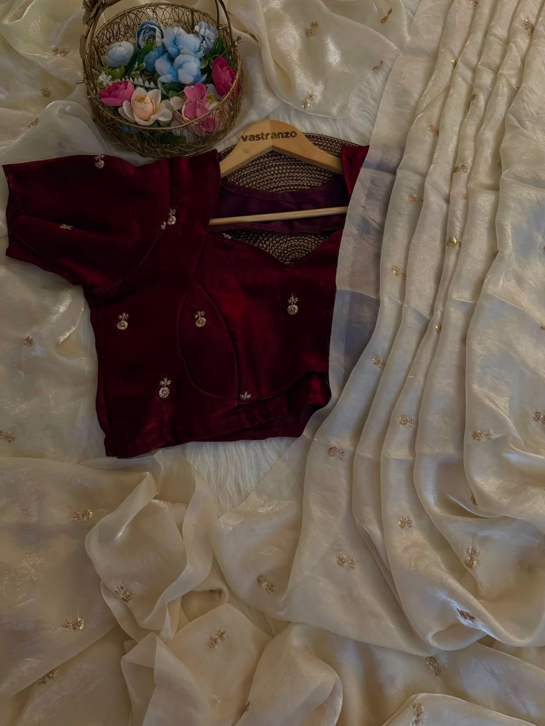 A Soft Beige Color Stardust Satin Saree Dual Shaded Sequins Jari Butti Work Allover the saree paired with Deep Maroon Color Sequins work Blouse