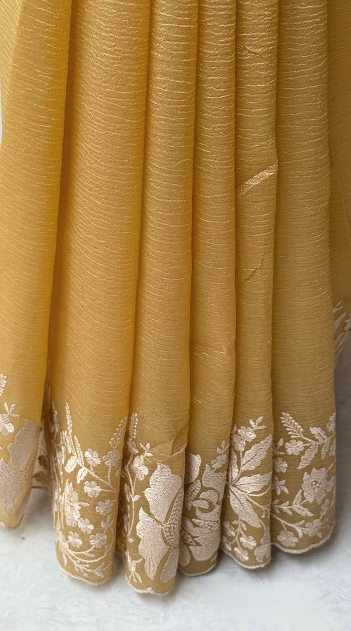 Gandham-hued crush organza saree, elevated with intricate ivory floral embroidery along the borders