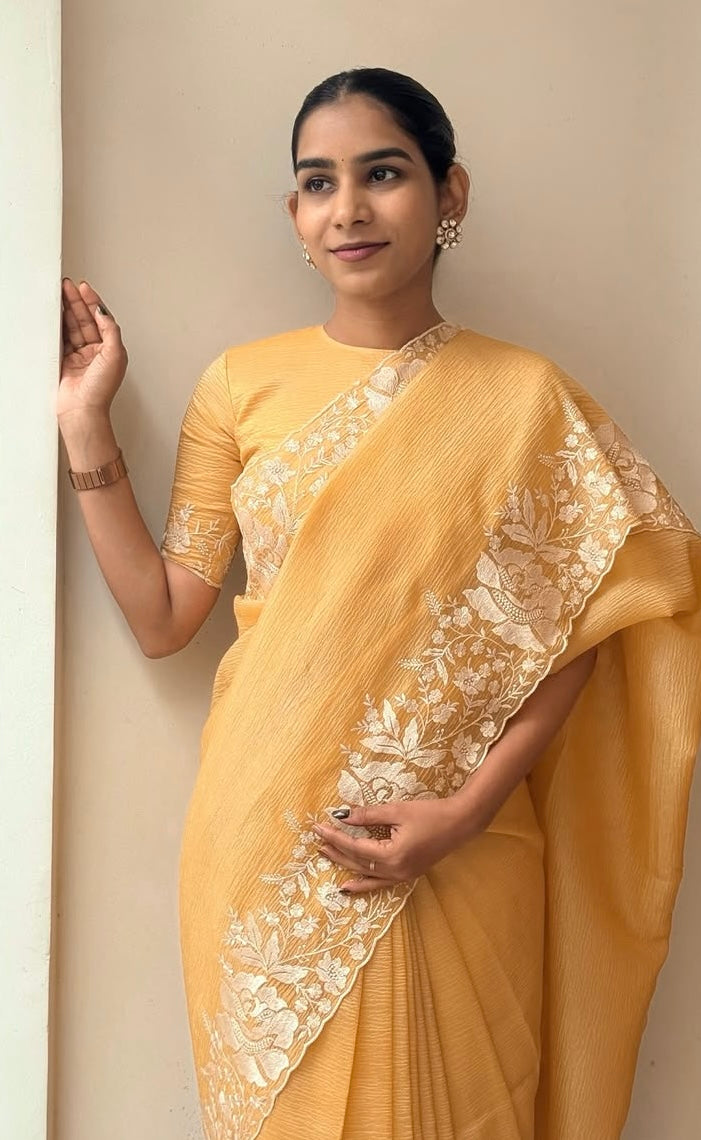 Gandham-hued crush organza saree, elevated with intricate ivory floral embroidery along the borders