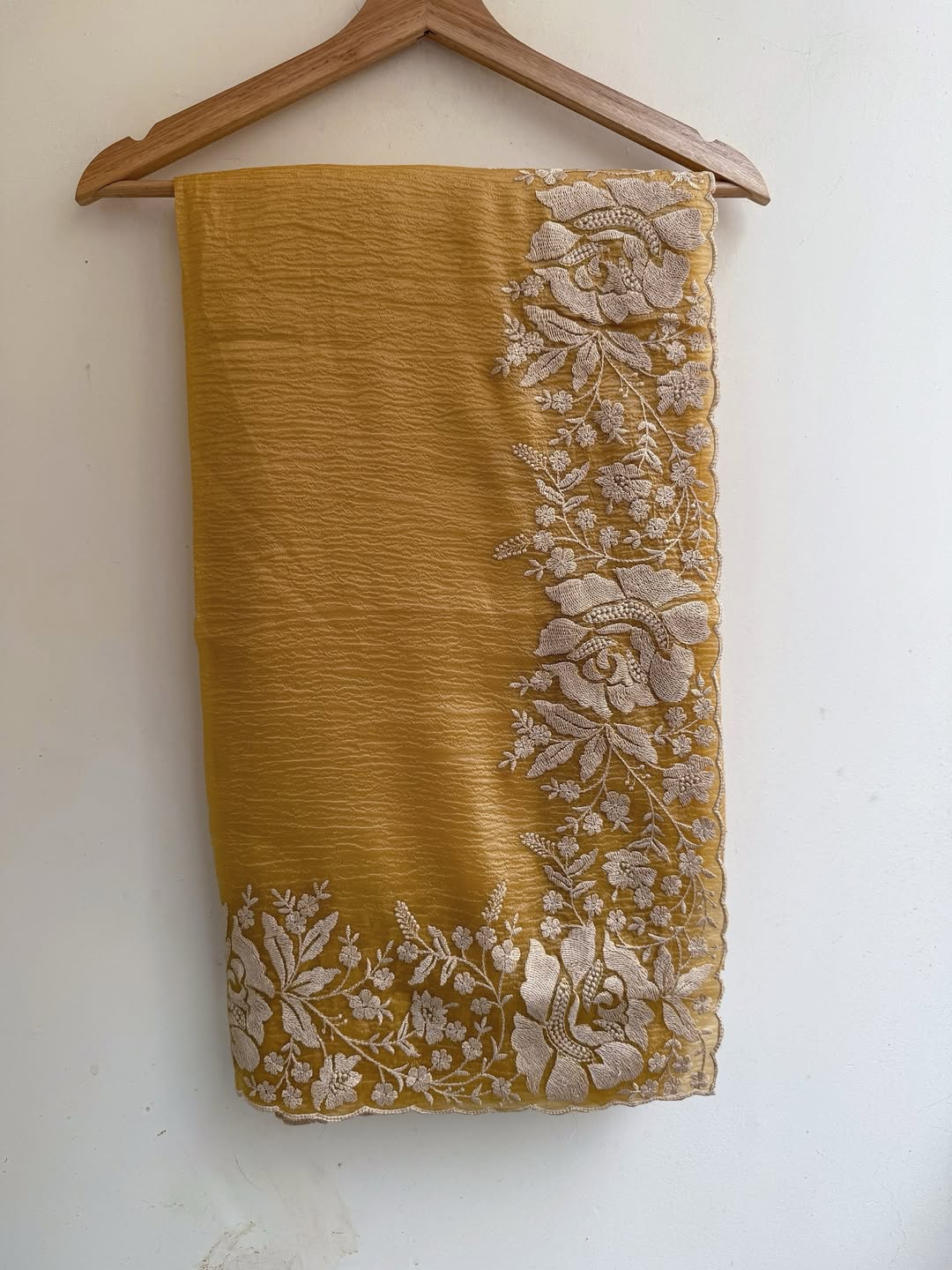 Gandham-hued crush organza saree, elevated with intricate ivory floral embroidery along the borders