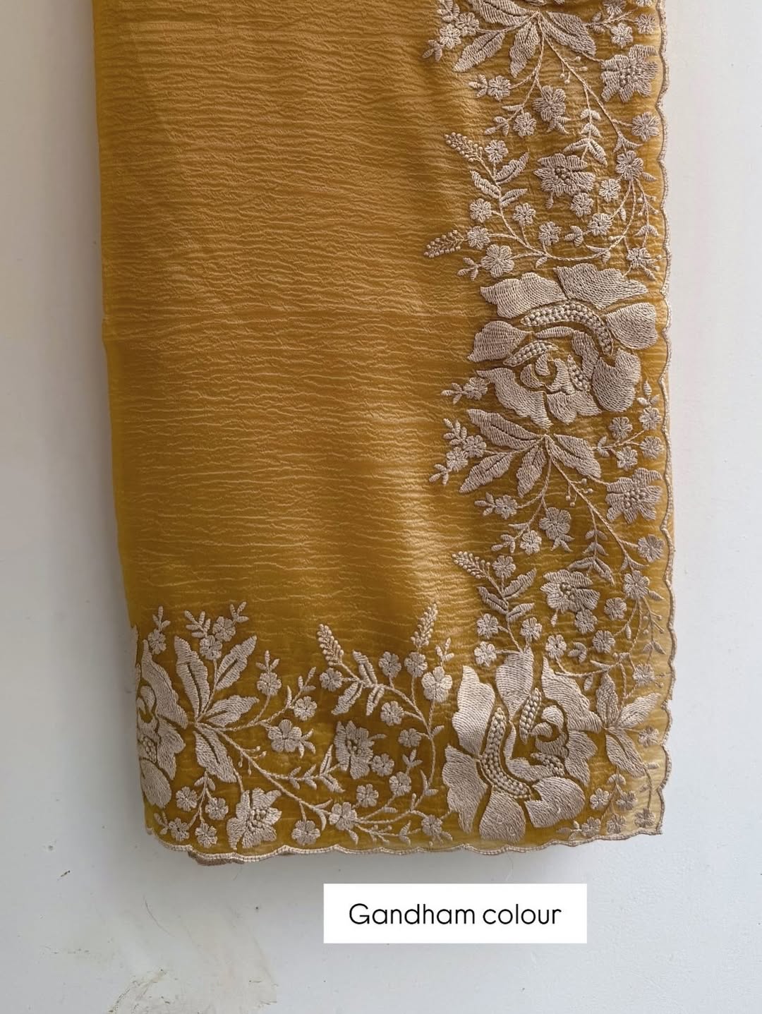 Gandham-hued crush organza saree, elevated with intricate ivory floral embroidery along the borders