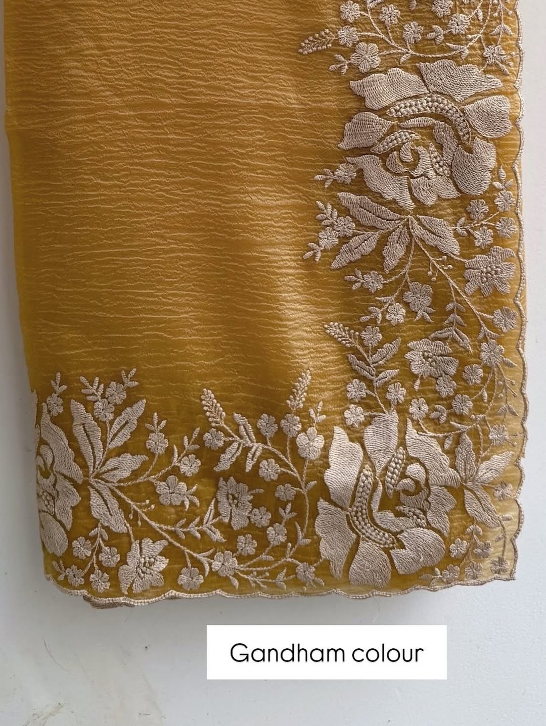 Gandham-hued crush organza saree, elevated with intricate ivory floral embroidery along the borders